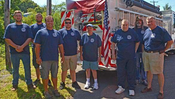 Members of the C.A. Lynch Hose Company, the American Flag and their new pumper truck. (photo by Robert Ford)