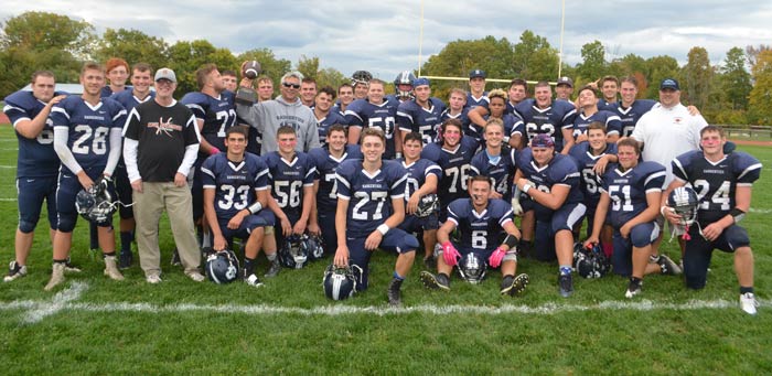 The Sawyer football team holds up the Mum/River Bowl after rolling over the Raiders of Red Hook Saturday. (photo by Robert Ford)