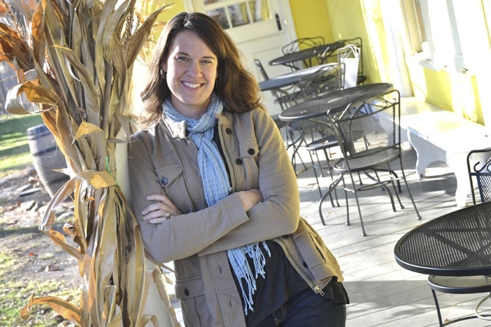Jennifer DuBois Bruntil has written a children's book titled, "Hugo the Huguenot."  She is descendant of the New Paltz Huguenot Dubois family and is pictured on the porch of the  DuBois Fort on Huguenot Street. (photo by Lauren Thomas)