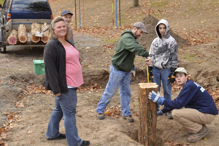 Troop 131 Boy Scout Kyiah Giannelli, center, and a number of his fellow scouts recently installed a log walking path at Seamon Park. Heidi-Jo Brandt, left, is looking on. Helping Giannelli were Caleb Vickery, Matt Morgan, Joe Giannelli, Erick Frank Ryan Curran and Ian Miller. (photo by Robert Ford)